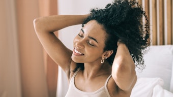 Woman Holding Curly Hair Up Relaxed Adobe Stock 557995121