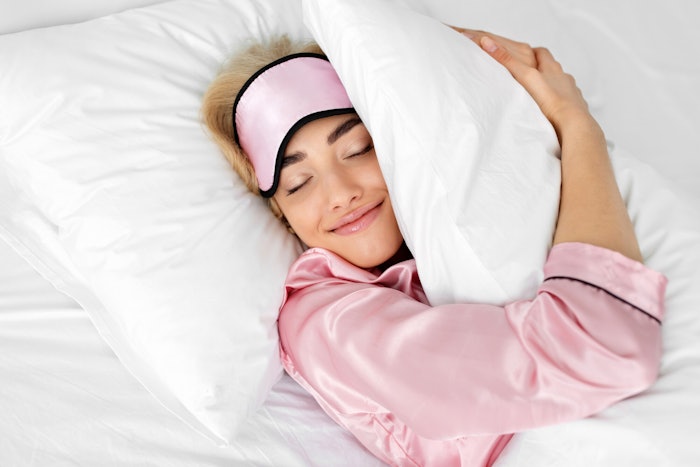 Woman In Bed In Pink Pjs Smiling Hugging Pillow Adobe Stock 1868783538 (1)