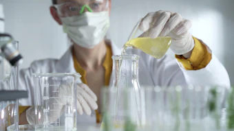 Chemist In Lab Mixing Beaker Adobe Stock 1640192867 (1)