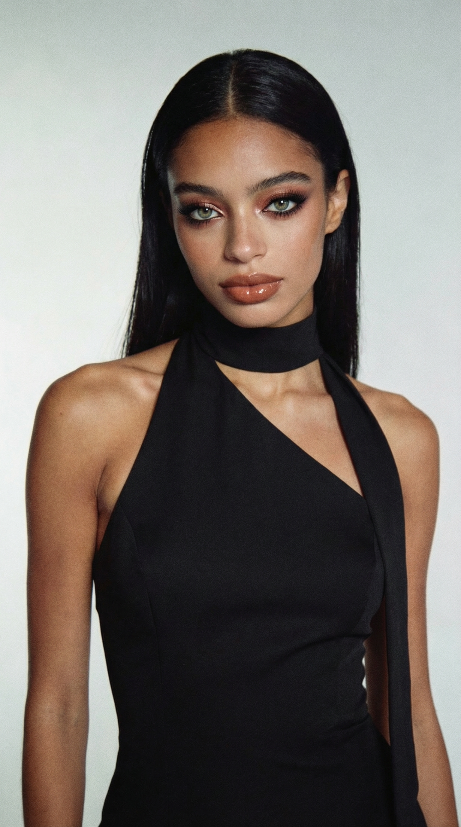 Woman in black halter top with sleek hair and dramatic makeup