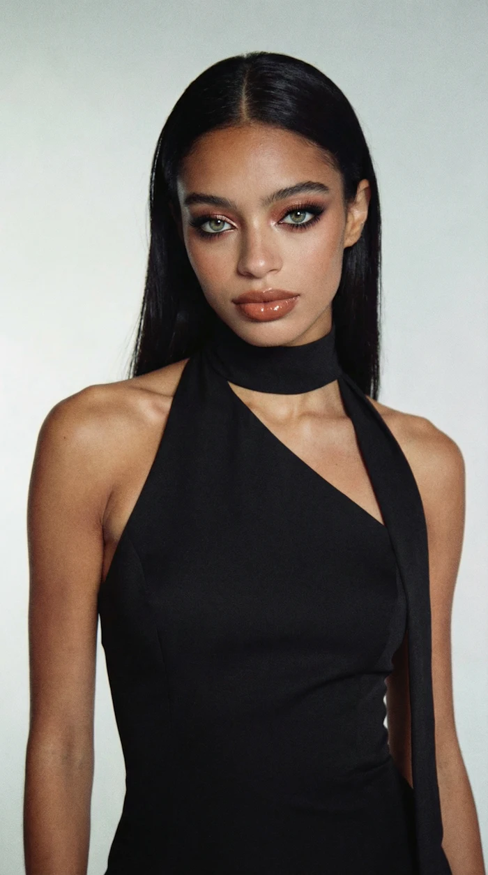 Woman in black halter top with sleek hair and dramatic makeup