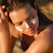 Woman applying white sunscreen to her face in natural sunlight