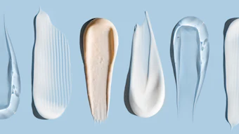 Array of cosmetic and skincare product swatches in white, cream, and pink tones on blue background