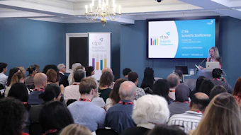 Audience members attending CTPA Scientific Conference presentation with speaker at podium and branded signage